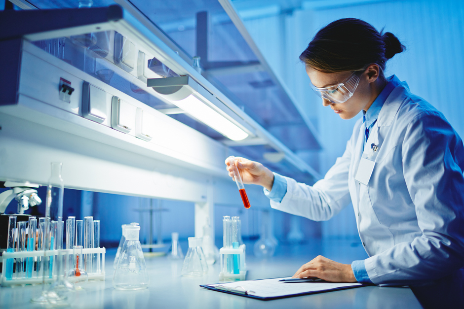 Female junior scientist with test tubes at work